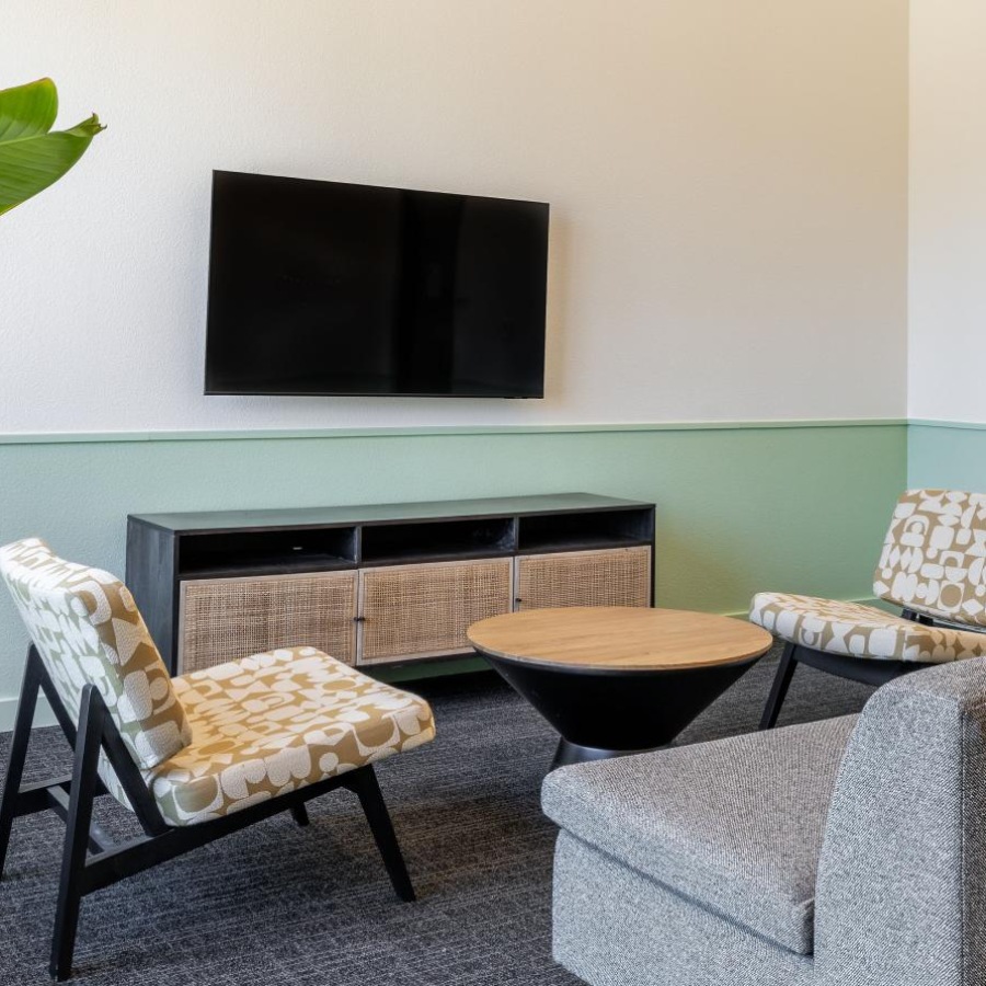 a clubroom with a tv, couch and chairs