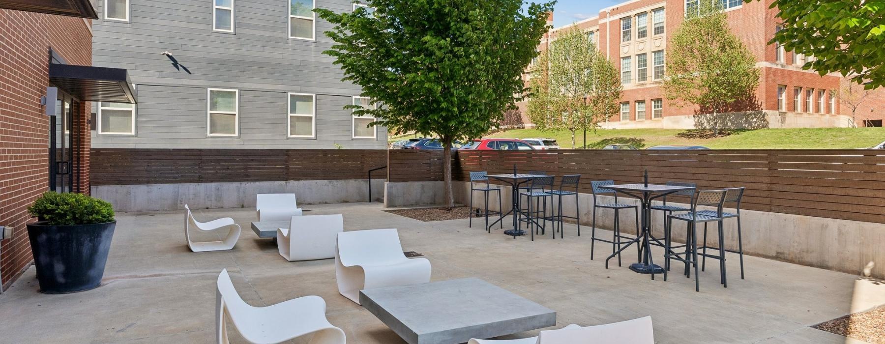 a courtyard with white chairs and tables