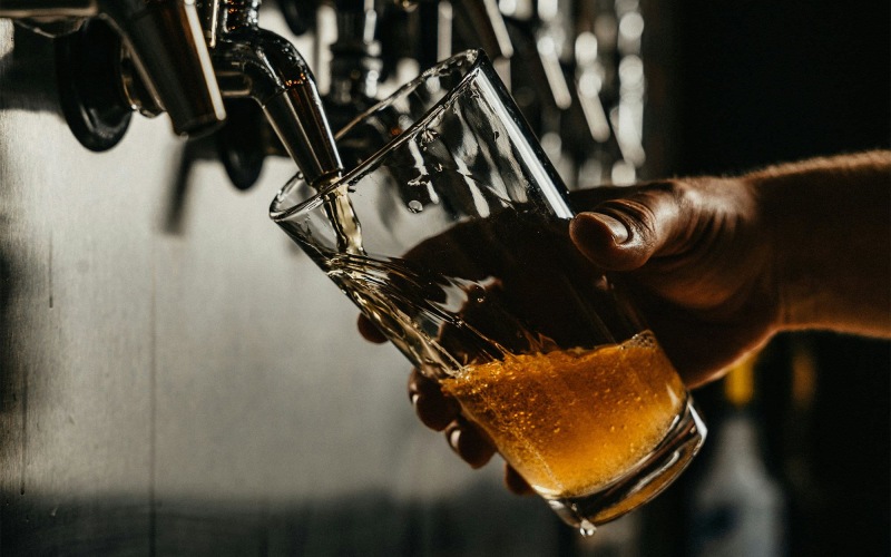 someone pouring a glass of beer