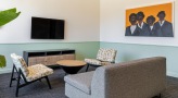a clubroom with a tv, couch and chairs